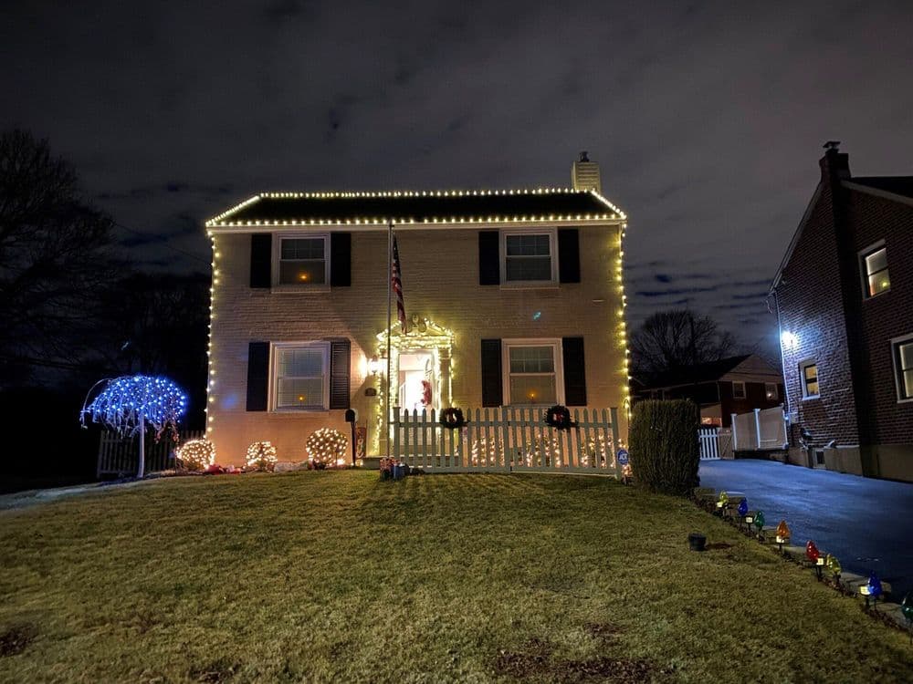Charming house decorated with festive lights for winter holidays at night.